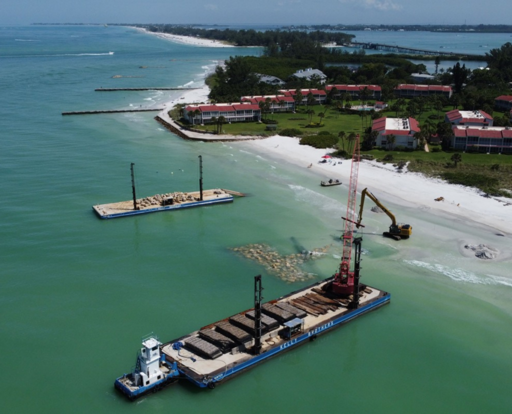 Aerial view of a beach and shoreline with visible construction activity.