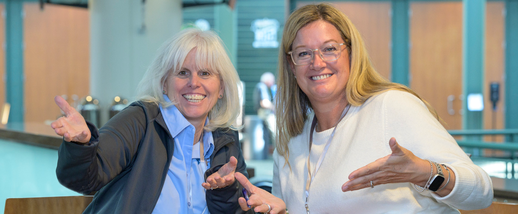 Two Foth members gesture a sign of welcome to new members