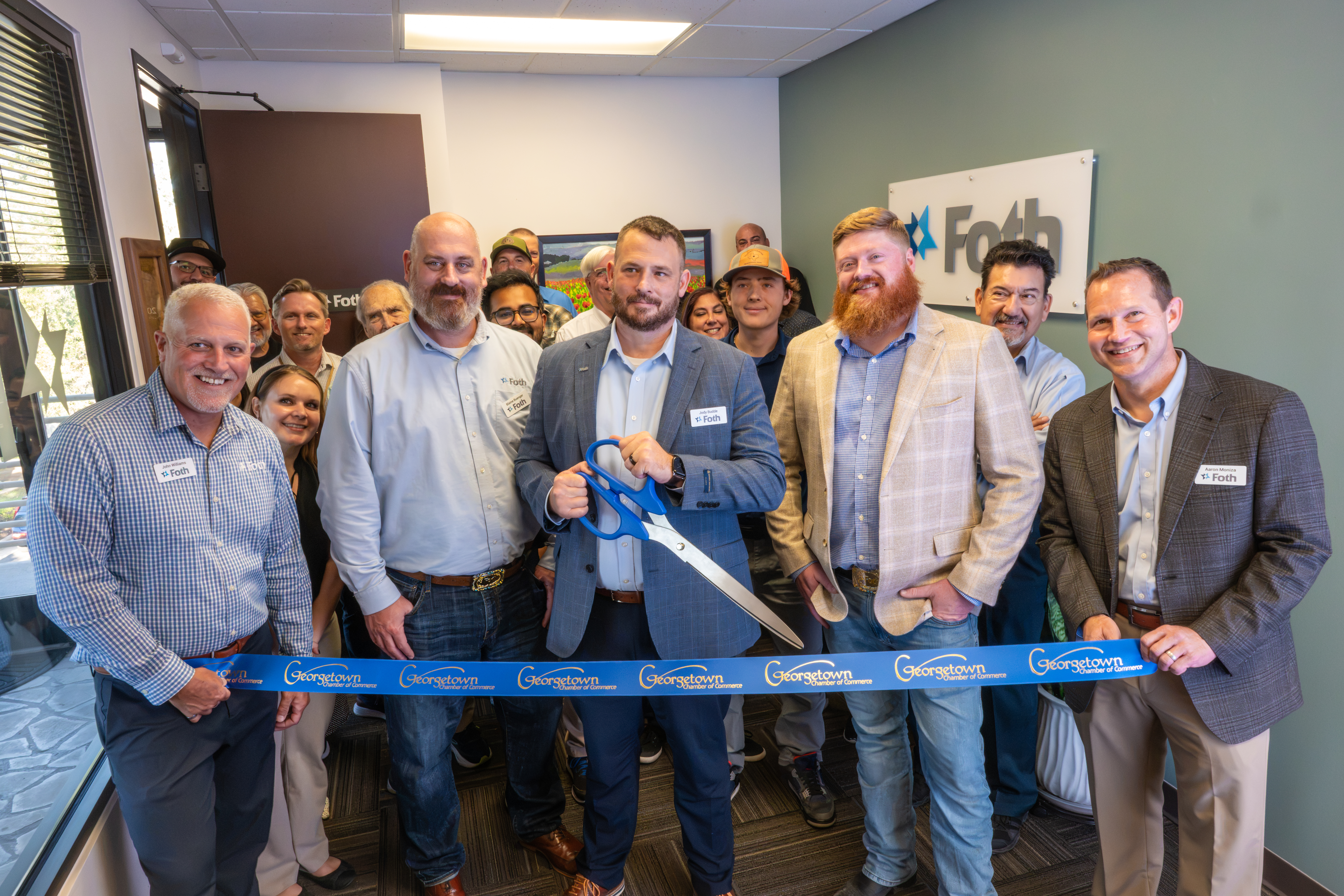 Group of Foth members and guests prepare to cut the ribbon officially opening the new office